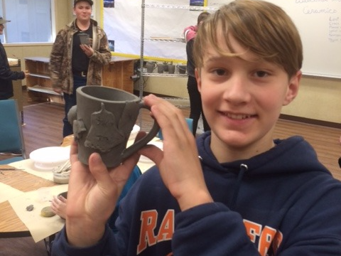 Pottery student showing off their mug